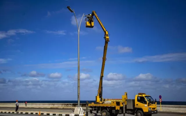 Imagen de una brigada de linieros trabajando en postes eléctricos en Cuba.
