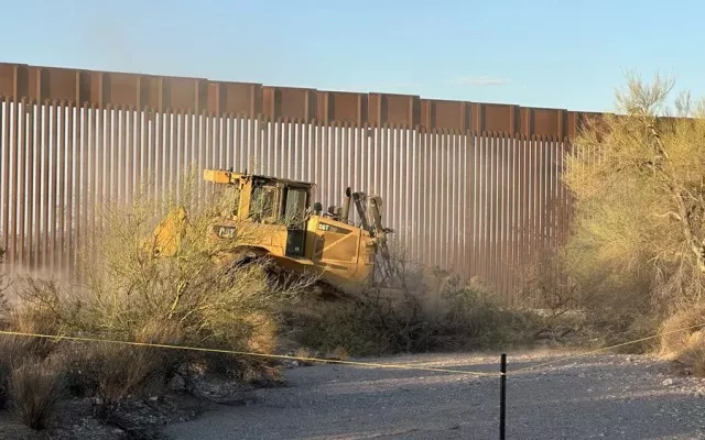 Maquinaria pesada trabajando en la construcción del muro fronterizo en Arizona.