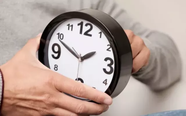 Reloj de pared analógico señalando un cambio de hora.