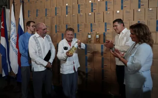 Autoridades cubanas y representantes rusos durante la recepción oficial de un cargamento de aceite vegetal como parte de una donación humanitaria.